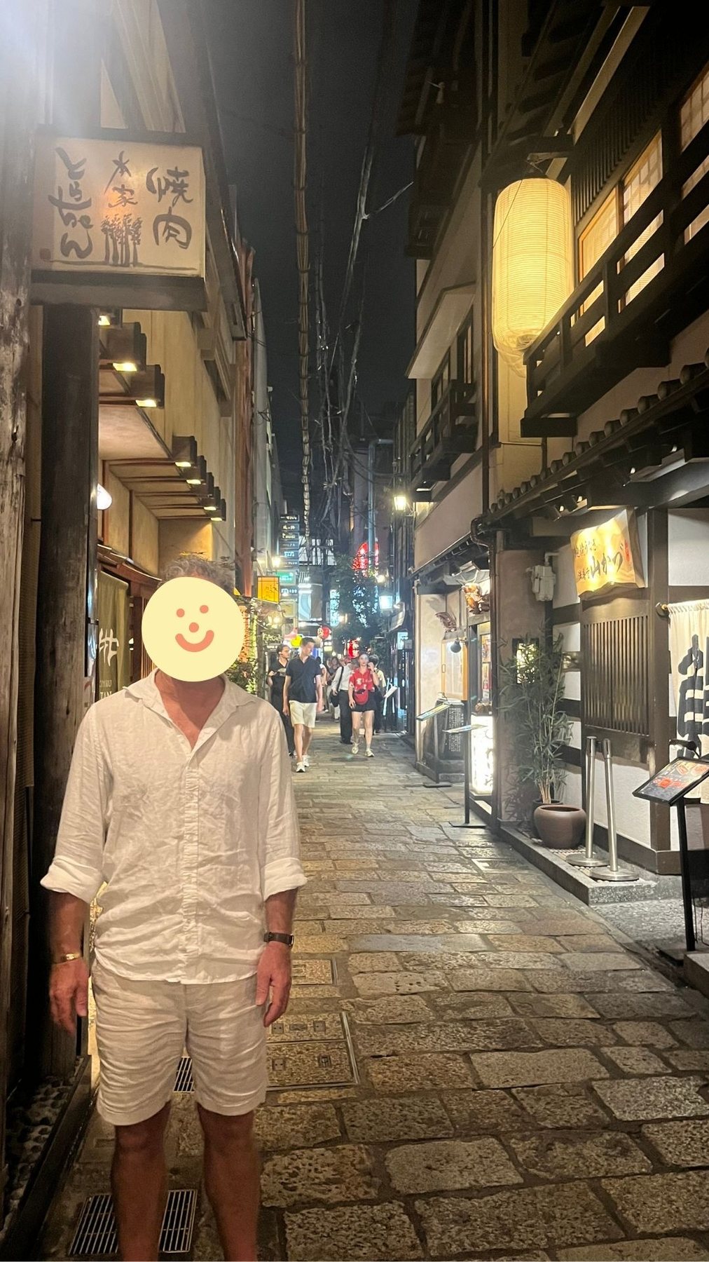 A guest in a lantern-lit Osaka dining alley