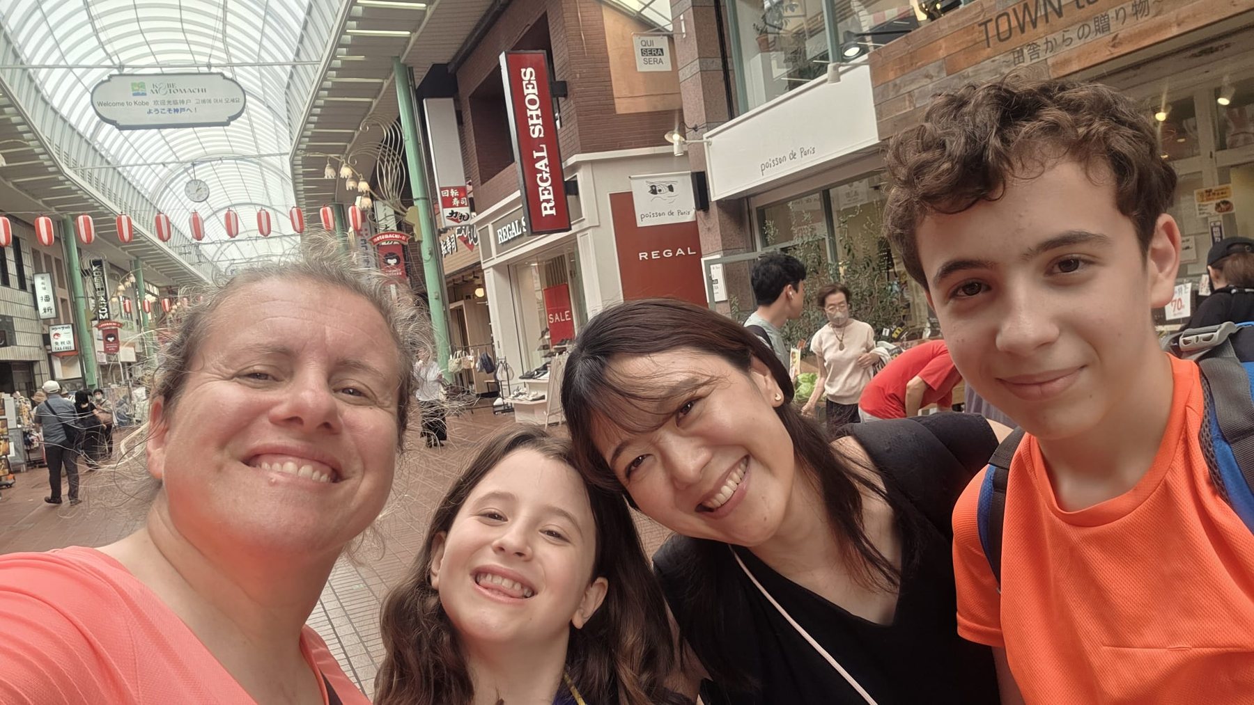 A family exploring a local shopping street in Kobe with Aki