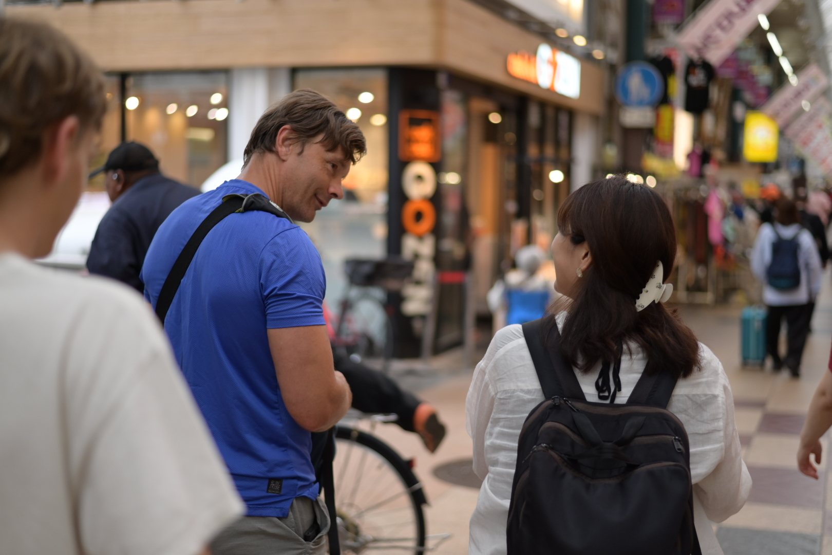 Aki guiding a guest through an Osaka shopping street